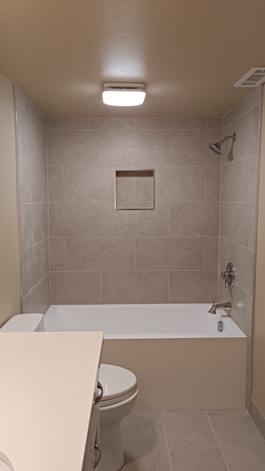 Bathroom remodel with beige tile bathtub-shower and niche in Portland