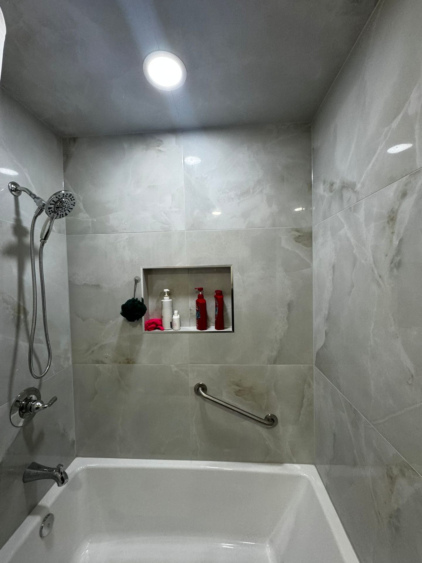 Bathroom remodel with marble tile tub and blue mosaic accent in Portland