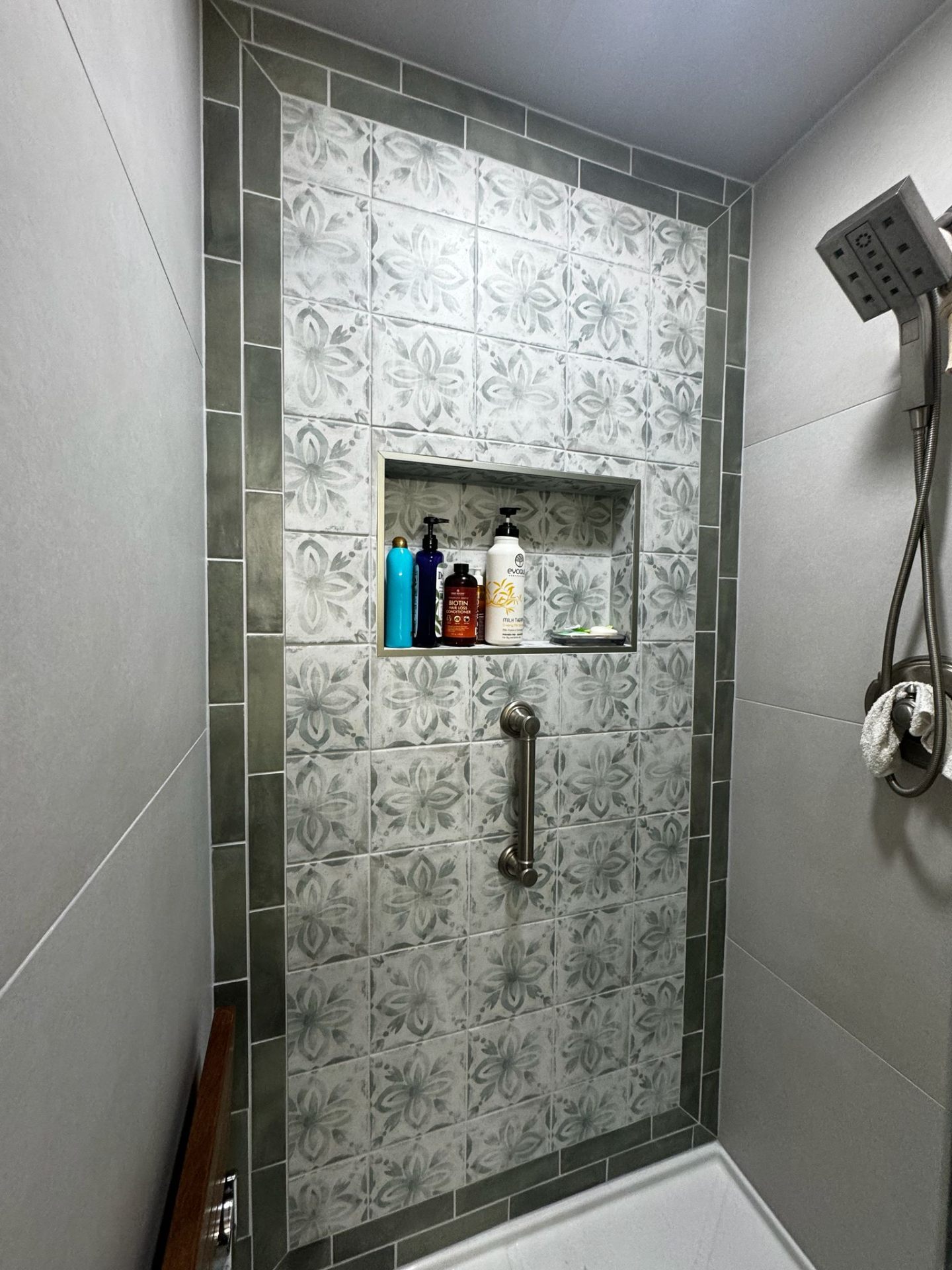 Bathroom shower with floral decorative tile and built-in niche in Portland