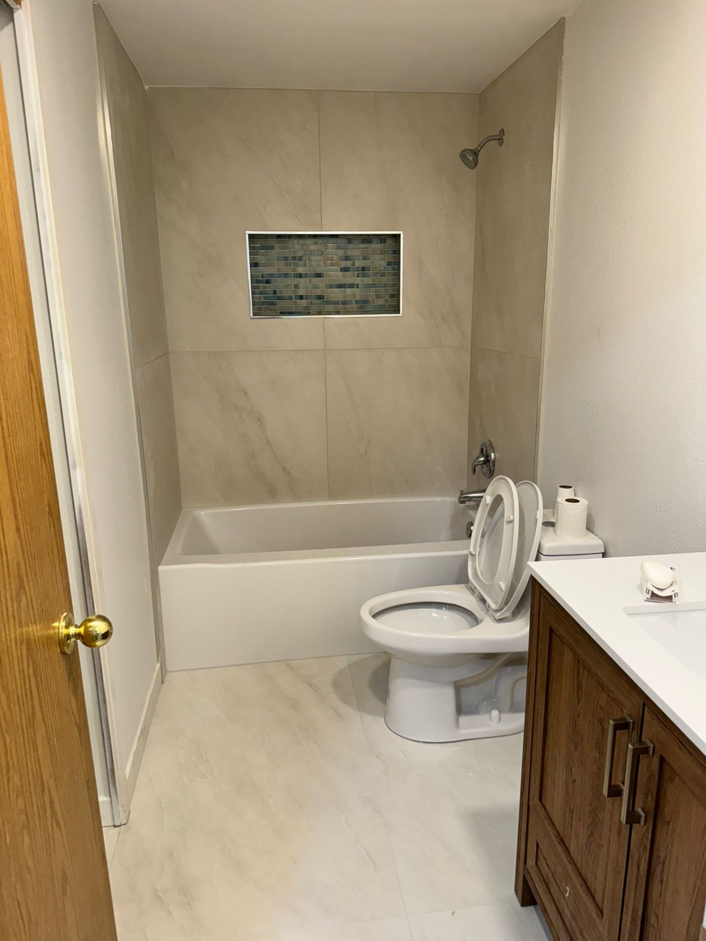 Bathroom tub-shower combo with marble tile and mosaic niche in Portland