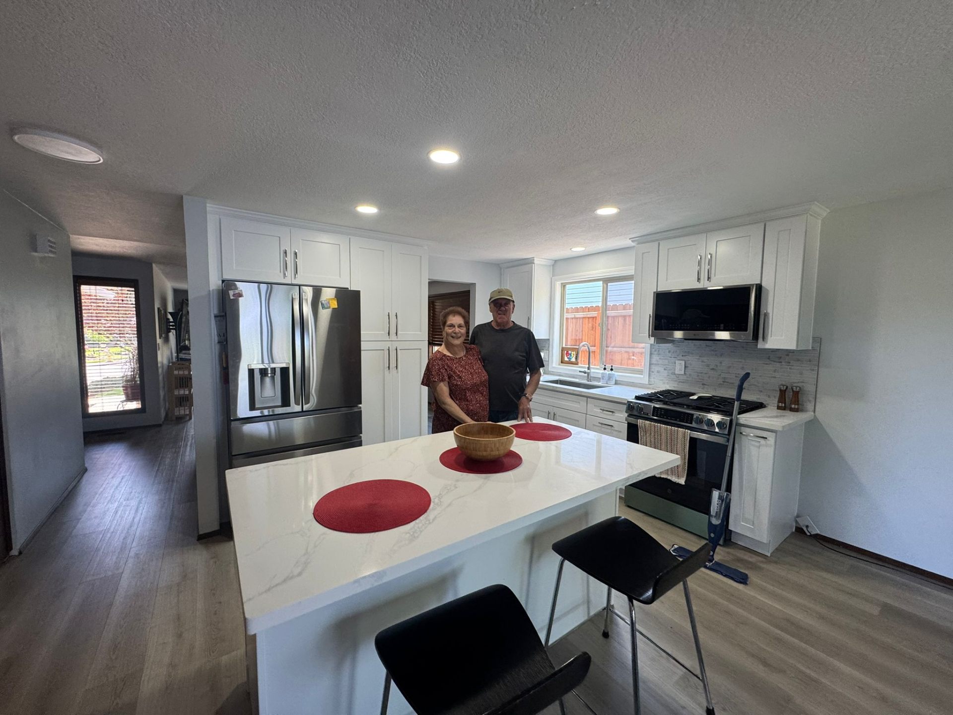 Completed kitchen remodel with happy homeowners, white cabinets and quartz countertops in Portland