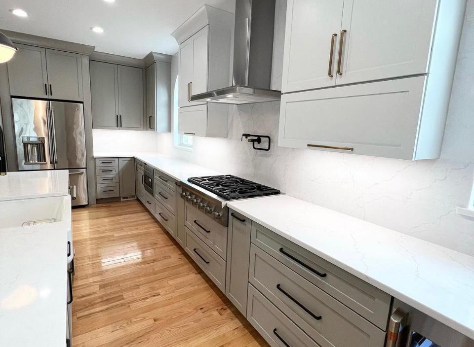 Gray kitchen with gas range, quartz countertop and range hood in Portland