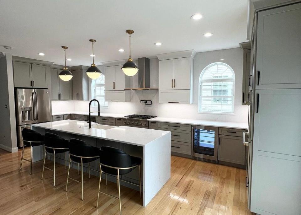 Gray kitchen remodel with large island, pendant lights and arch windows in Portland