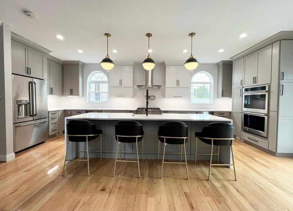 Gray shaker kitchen with island, bar stools and double oven in Portland