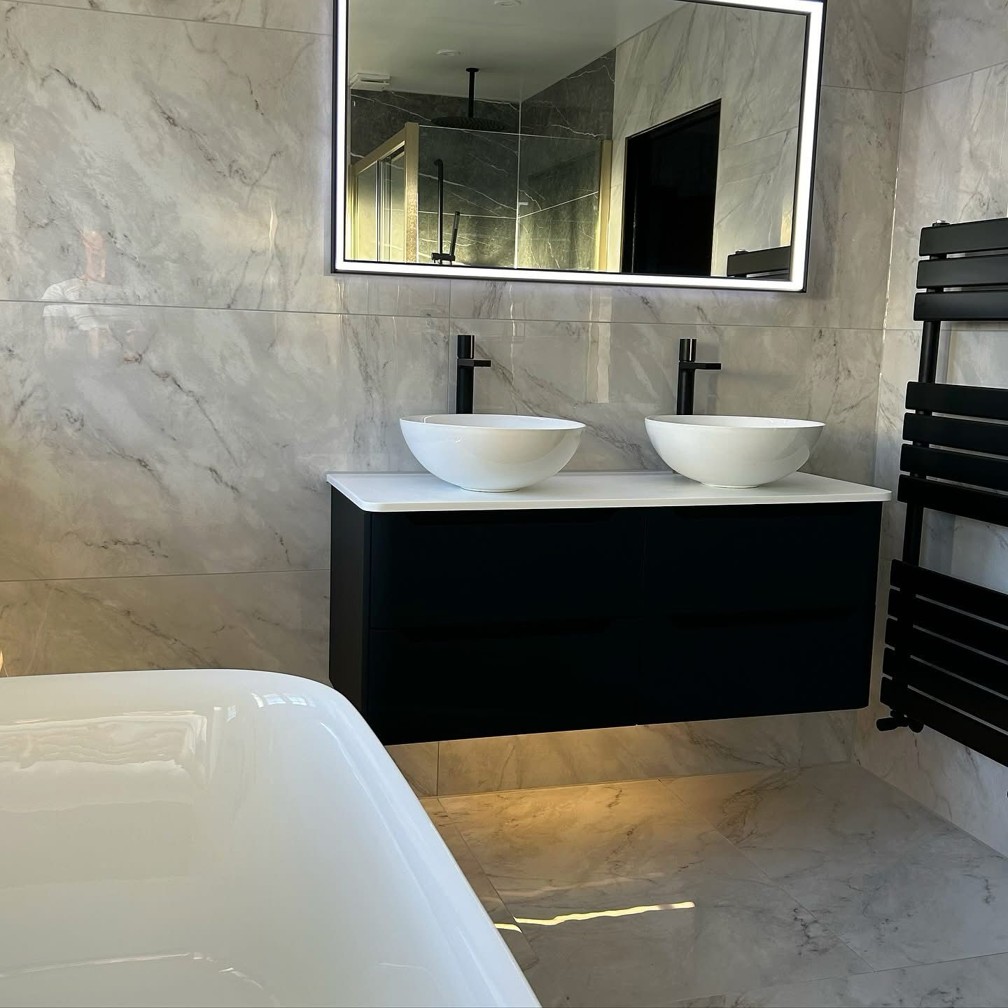 Luxury bathroom with double vessel sinks, floating vanity and marble tile in Portland