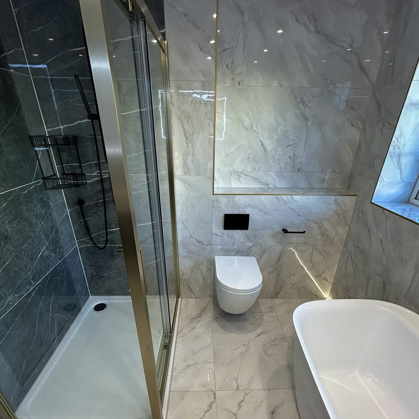 Luxury bathroom with gold-trim glass shower, wall-mounted toilet and soaking tub in Portland