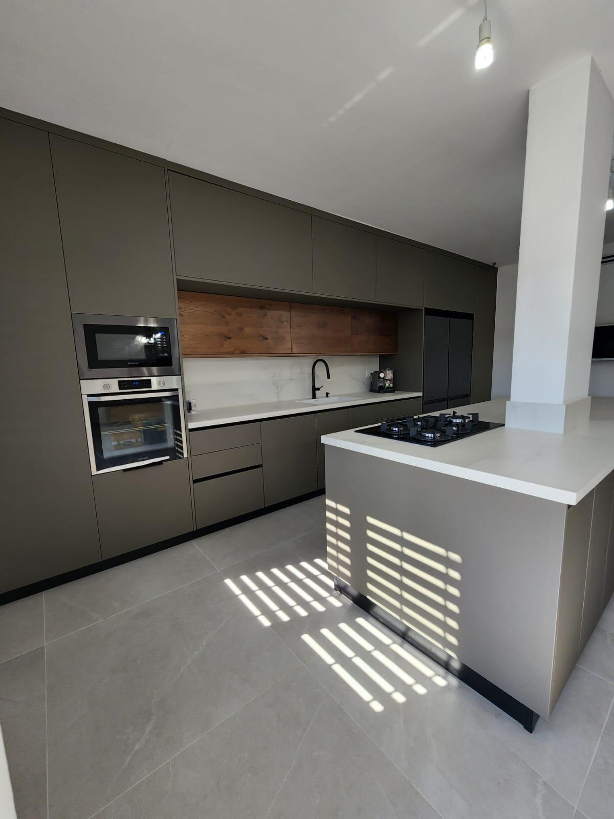 Modern dark kitchen remodel with built-in appliances and gas cooktop in Portland