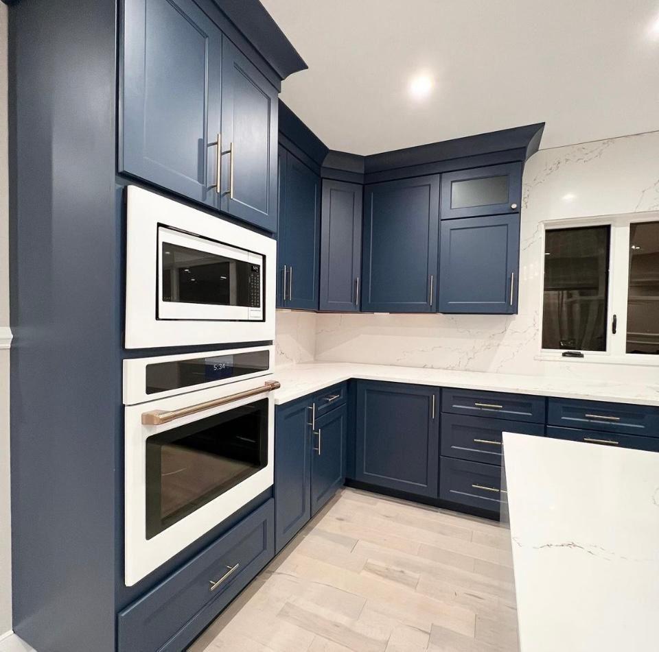 Navy blue kitchen with wall oven, quartz countertop and marble backsplash in Portland