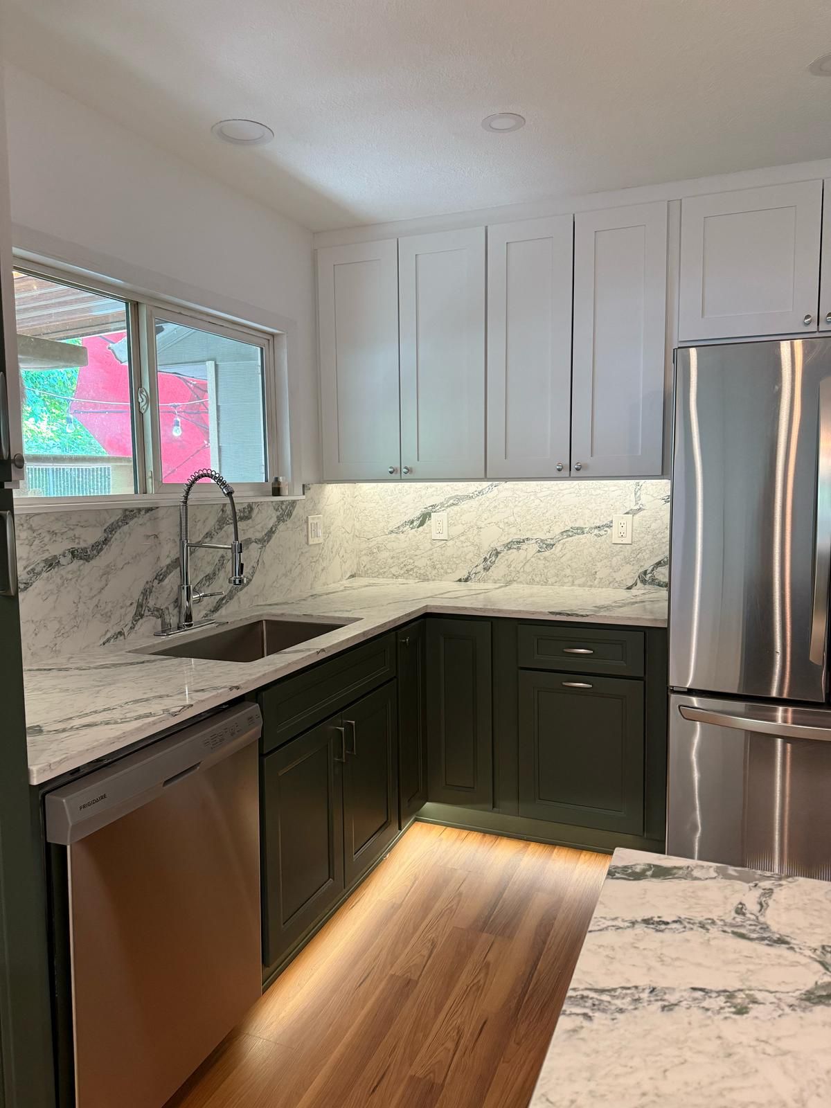 Two-tone kitchen with dark lower cabinets, light uppers and marble backsplash in Portland