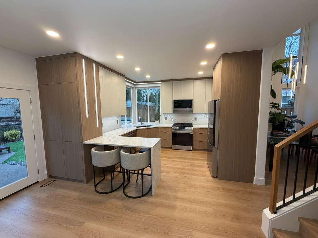 Two-tone kitchen with wood accent, LED lights and quartz peninsula in Portland
