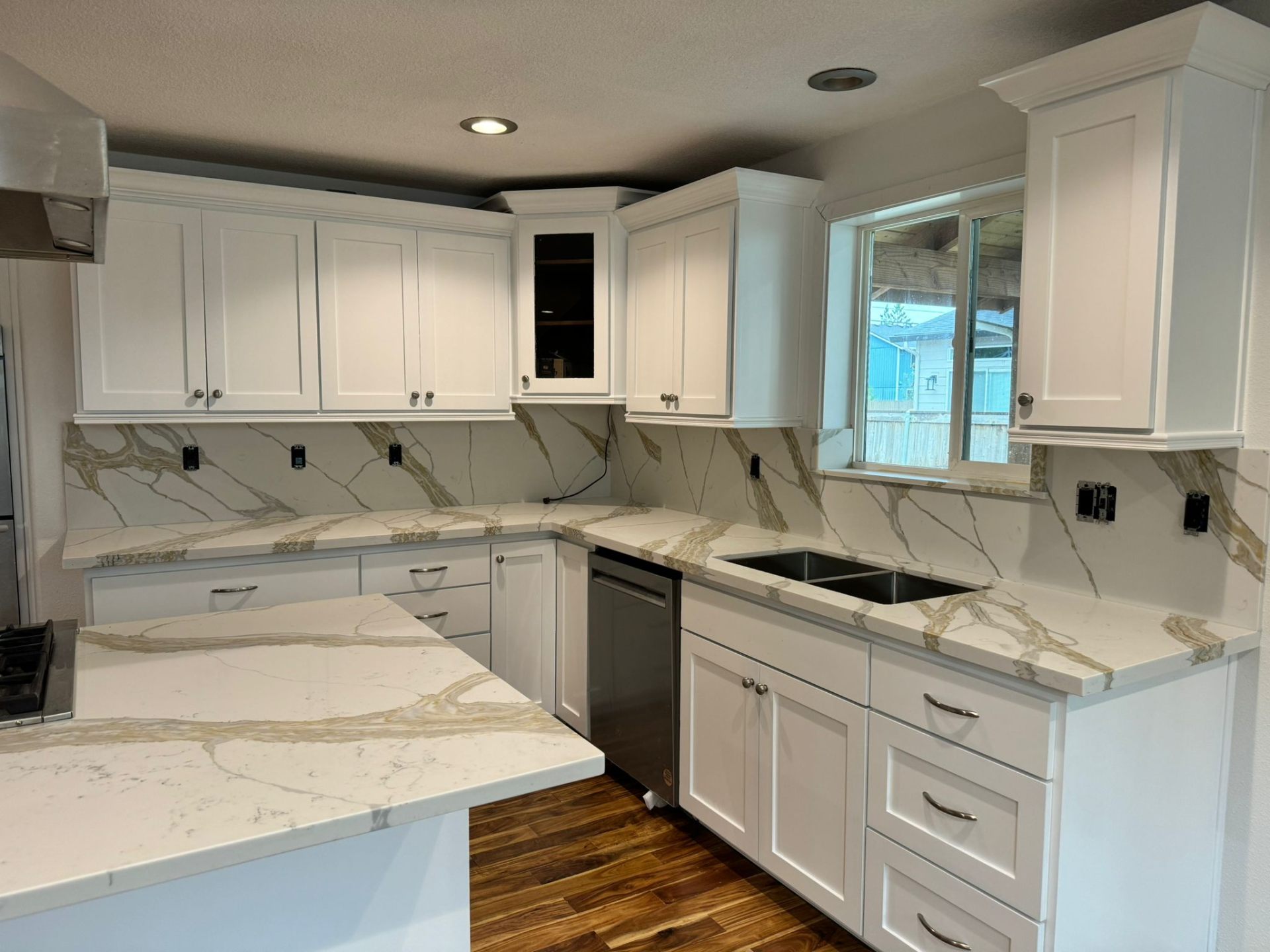 White kitchen with quartz countertops and dramatic marble backsplash in Portland