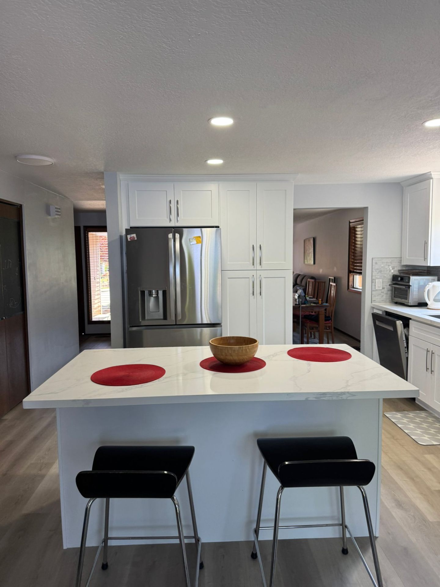 White kitchen remodel with quartz island and stainless refrigerator in Portland